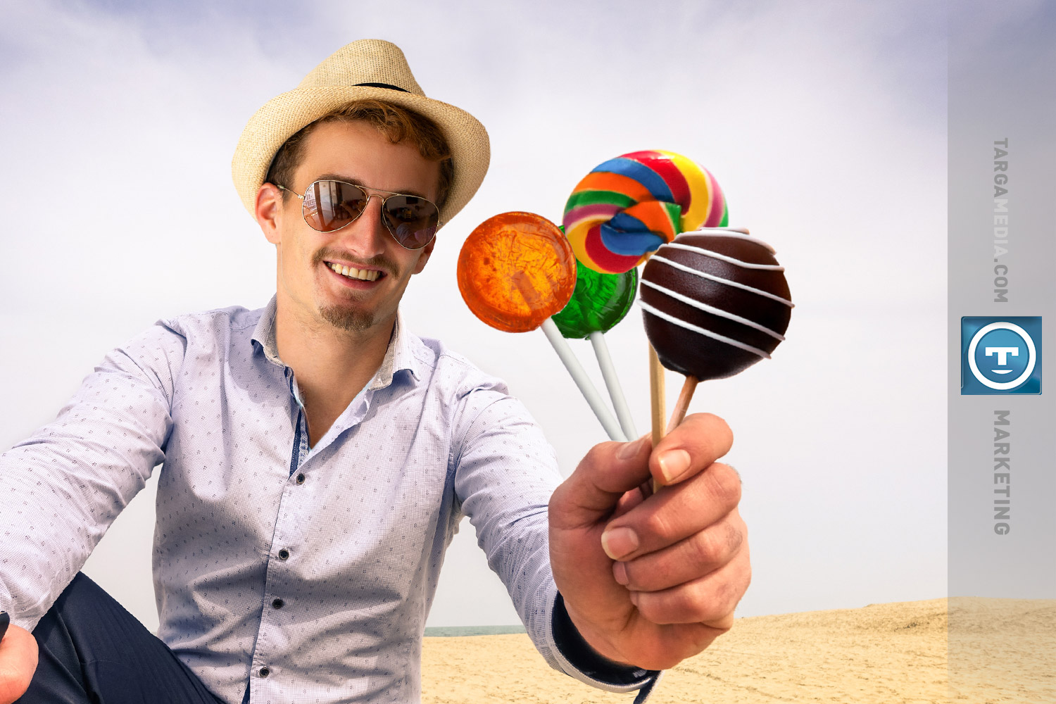 Man wearing a fedora and shades in the desert holds out lollipops